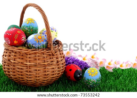 Hand painted beautiful  colorful  easter eggs in wicker basket on fresh green grass
