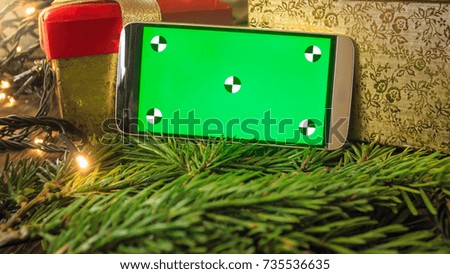 Closeup image of smartphone with empty green screen on mobile phone