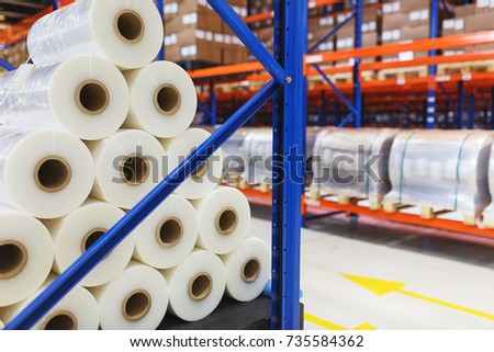 system of address storage of products, materials and goods in a warehouse. Rolls of polyethylene film in stock. Modern warehouse and storage systems.