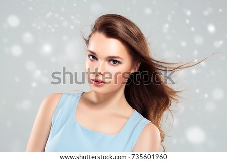 Beauty Woman Winter Snow face Portrait. Beautiful Spa model Girl with Perfect Fresh Clean Skin female smiling on color background. Beautiful hairstyle Youth and Skin Care Concept