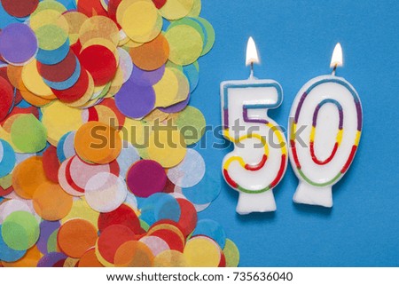 Number 50 celebration candle with party confetti
