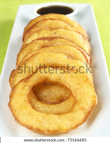 Popular Peruvian dessert called Picarones made from squash and sweet potato and served with Chancaca syrup (kind of honey) (Selective Focus, Focus on the upper part of the first ring)
