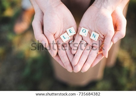 Couple holding the letters of babie's name LEON