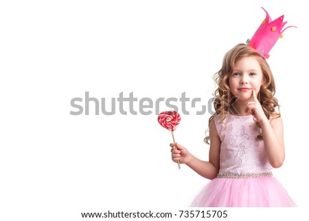 Beautiful little candy princess girl in crown holding big pink heart lollipop and smiling Royalty-Free Stock Photo #735715705