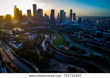 aerial drone view high above Houston Texas Downtown Sunrise Sunburst over Urban Sprawl Interstate roads , Buffalo Bayou River Park , and Downtown Skyline background 