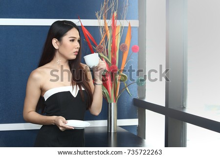 Asian Office Girl drink coffee white cup in blue office room white windows and flower