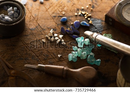 Exploring mining, and inspecting gems. Treasure hunting. Gold and gems on rough wooden surface. Royalty-Free Stock Photo #735729466
