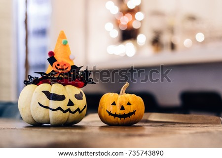 Halloween pumpkins with painted faces on a wooden table background of bokeh,little space for text 