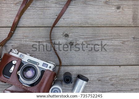 old still camera in brown leather case on wooden table