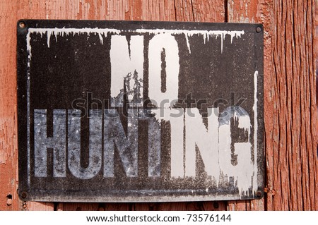 Close-up of "No Hunting" sign on a decrepit barn