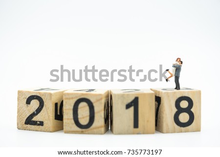 Miniature people, couple on wooden block 2018 text on coins stacks as background, success, dealing, business planner, forecast concept.