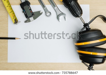 Top view of protective tool, measurement tool and wrench on blank  paper background.