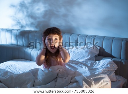 Night terrors of the child. Fear of the dark. The baby on the bed at night. An empty space to insert text. Royalty-Free Stock Photo #735803326