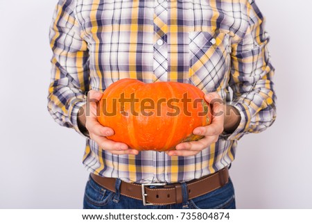 Close up of farmer holding a pumpkins on a light background studio