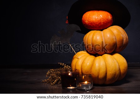 composition for decorating a house for halloween, yellow and orange pumpkins, burning candles, drawings of black bats