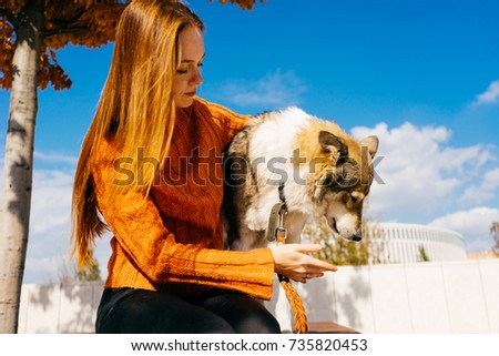 beautiful red-haired girl walking with her big gray dog