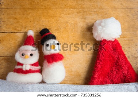 Top view or flat lay of cute santa claus and snowman doll oranament decoration on wooden table with christmas tree, merry christmas, happy new year concept background