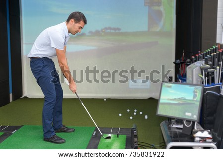 young golf player having playing video-game golf indoors