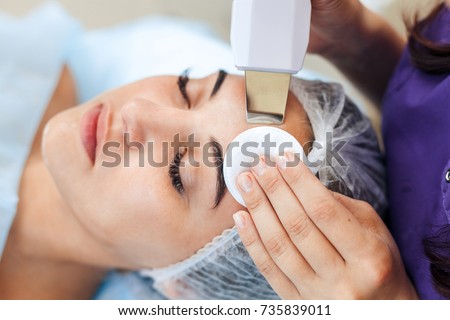 Face skin care. Woman getting facial ultrasound cleaning at beauty salon Royalty-Free Stock Photo #735839011
