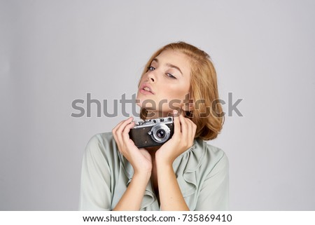 woman photographer with a camera on a light background                               