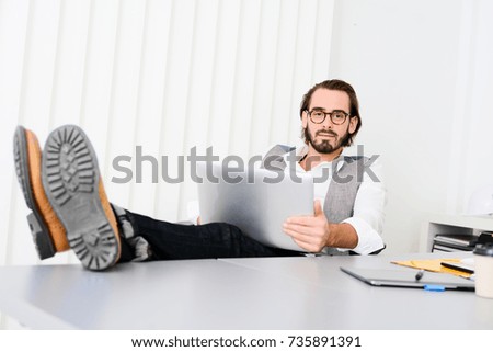 handsome young trendy successful business man in casual wear working in a start up office