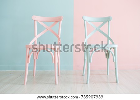 Vintage pastel horizontal wooden chair painted on two tone background Royalty-Free Stock Photo #735907939