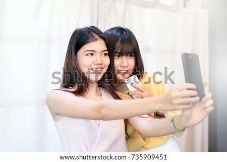 Portrait of beautiful asian young woman smiling teeth,Happy fun and selfie with smart phone