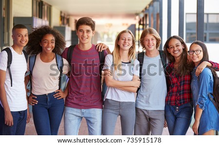 Teenage classmates standing in high school hallway Royalty-Free Stock Photo #735915178