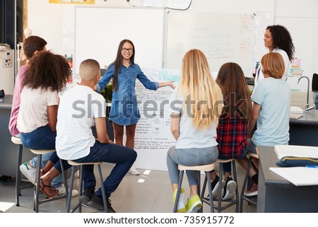 Schoolgirl presenting in front of science class, close up