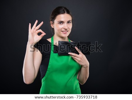 Attractive girl seller doing okay gesture sign after receiving sallary and looking satisfied