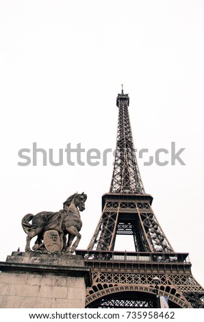 Statue hero horse standing side by side the Eiffel Tower is a popular attraction for tourists with isolated white background, Paris, France.