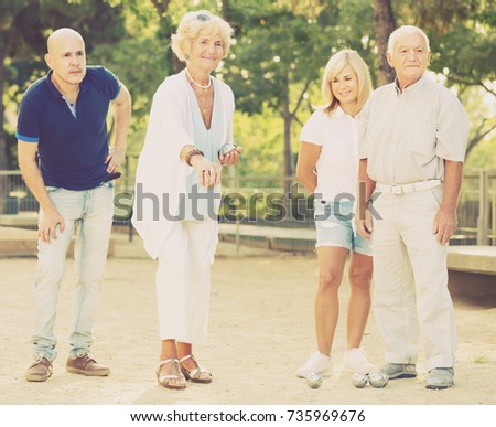 Group of mature people playing petanque in park at sunny day outdoor