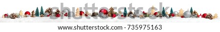 Christmas border or banner with ornaments arranged in a row on snow, extra wide and isolated on white background