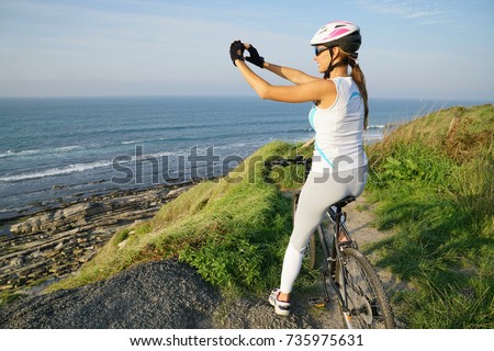 Woman on bike ride taking picture of scenery