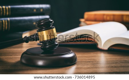 Law studies. Judge gavel on a wooden desk, blur legal books background