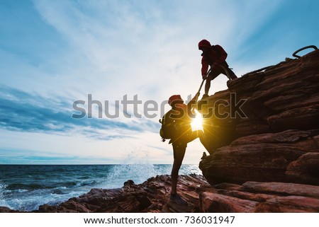 Young asian couple climbing up on the mountain,hiking and team work concept. Royalty-Free Stock Photo #736031947