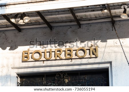 Vintage bourbon address sign in New Orleans, the world famous Bourbon Street at French Quarter as party atmosphere.