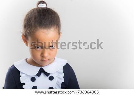 african Small girl with looking seriously, folding hands and frowning eyebrows. Her gloomy appearance says she is very unhappy and offended. baby showing disapproval with pursed lips Royalty-Free Stock Photo #736064305