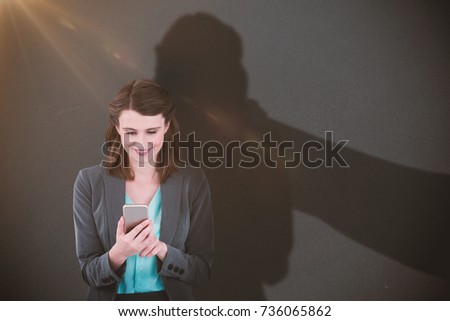 Businesswoman using mobile phone against grey