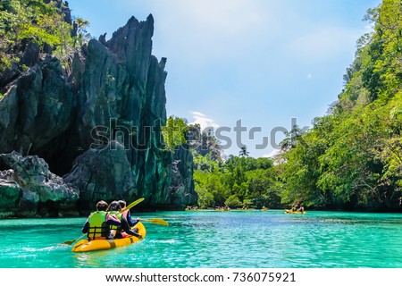 Kayaks in the big lagoon with turquoise clean water, tropical forest , rocks,,  El Nido, Palawan, Philippines Royalty-Free Stock Photo #736075921