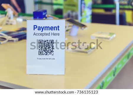 QR code payment, cashless technology concept : Slant back acrylic sign holder or display stand with QR code in electronic appliance store. QR code is a matrix barcode stores information of an item.