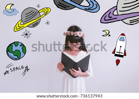 Young Asian girl kid wearing glasses reading a science book with stars and space  illustrator doodles -  astronomer kid with space and science concept