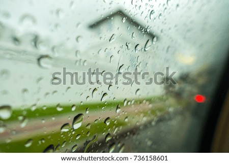 Raindrop on Windshield and car mirror on Traffic in rainy season
