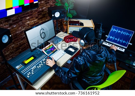asian male sound engineer working in digital audio & video editing post production studio