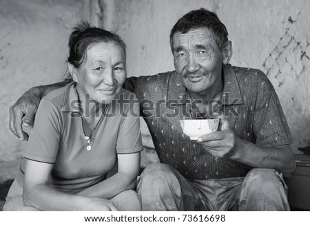 A man and a woman of Asian appearance have tea at home