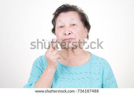 Asian Senior woman smoking cigarette over white background