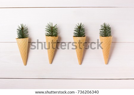 Christmas composition. New year background. Ice cream cones with fir branches on wooden white background. Flat lay, top view with copy space for your text.