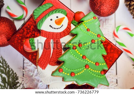 Hot chocolate cup with marshmallow, gingerbread snowman and christmas gift on white wooden background