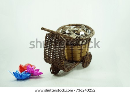 Full coins in bamboo basket . Motorcycle money basket on white background. Save money concept. selective focus