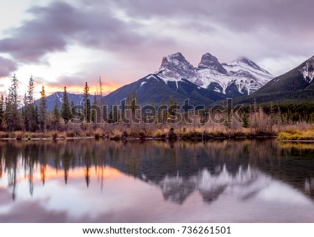 Sunrise view of  Policeman's Creek along the Bow River outside Canmore, Alberta in winter.  Pictured is the famous mountain known as the Three Sisters.